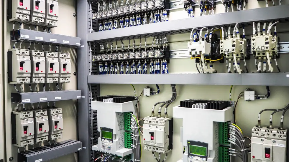 Electrical control panel with relays and circuit breakers.