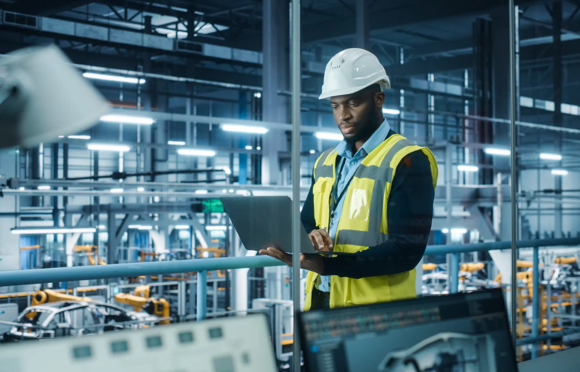 Engineer working on laptop in factory.