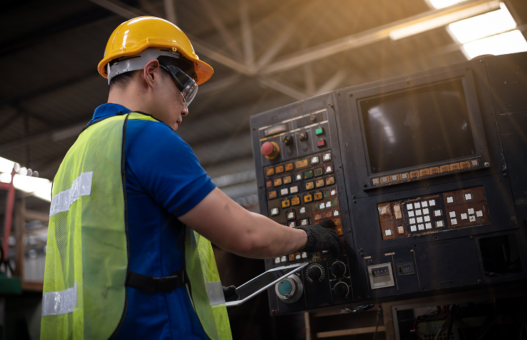 Worker operating industrial machine in factory.