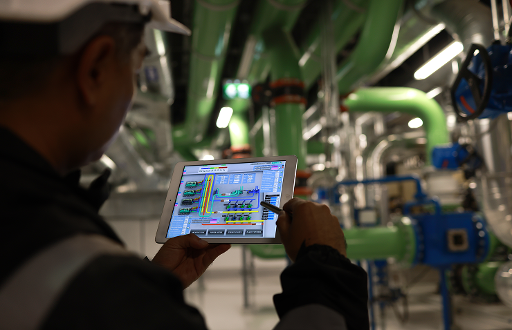 Engineer using tablet in industrial facility.